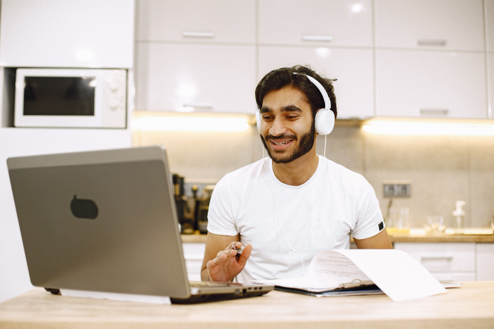 arabic-man-watching-online-webinar-sitting-kitchen-with-computer-enjoying-distance-learning